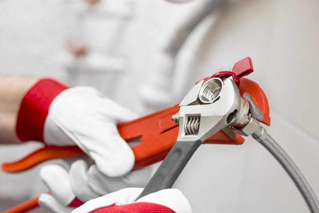 Plumber holding pipe wrenches for an emergency repair in Cartersville