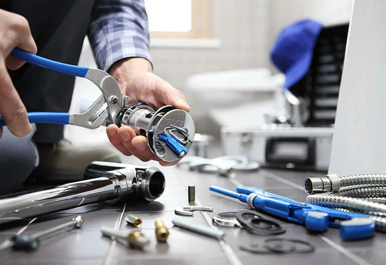 Technician repairing a plumbing fixture with professional tools in Cartersville