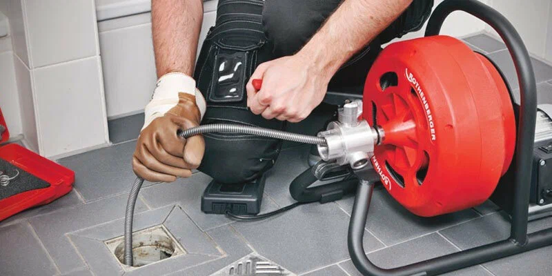 Plumber using a drain-cleaning machine in Cartersville