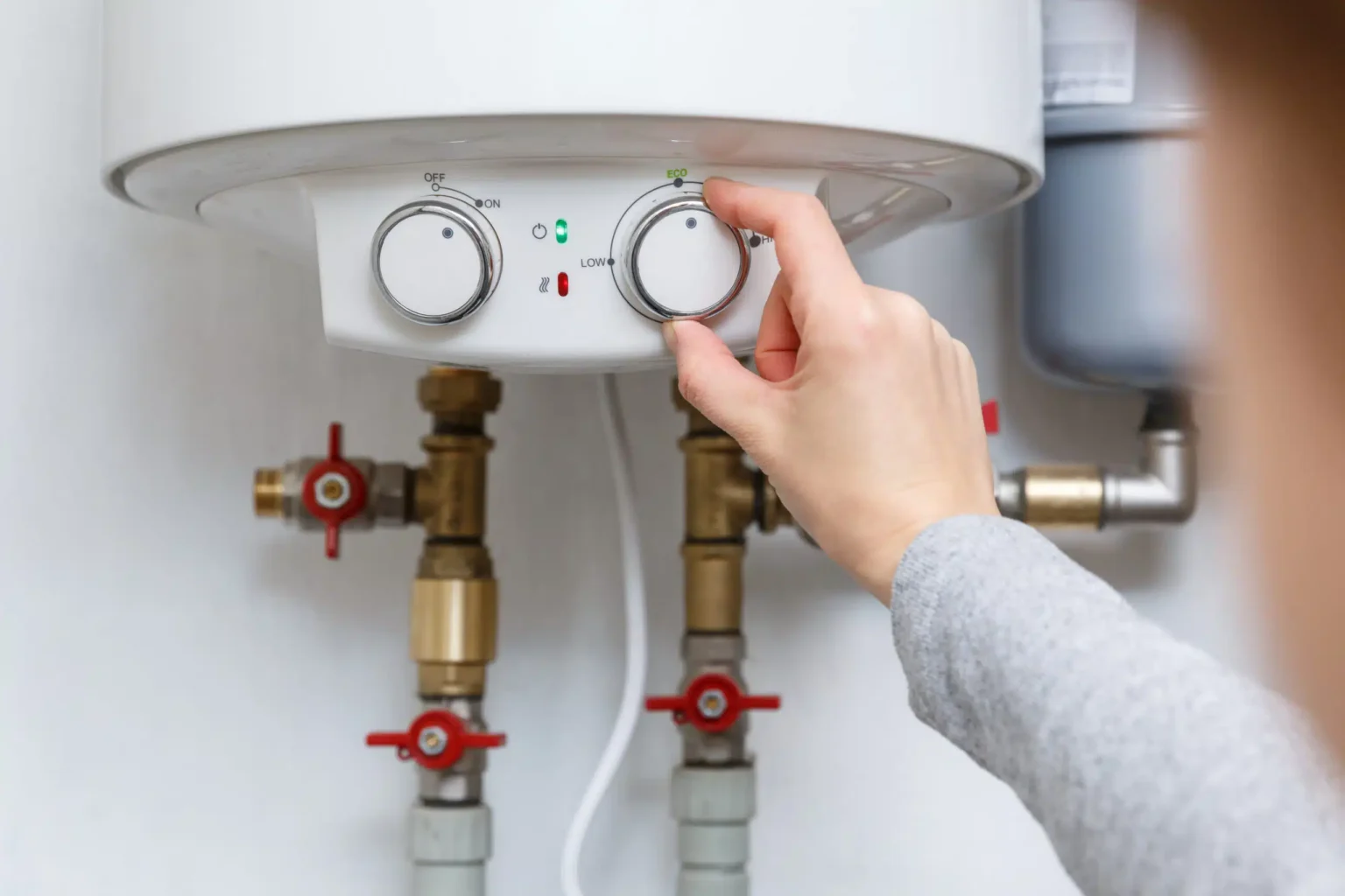 Homeowner adjusting the temperature controls on a water heater in Cartersville